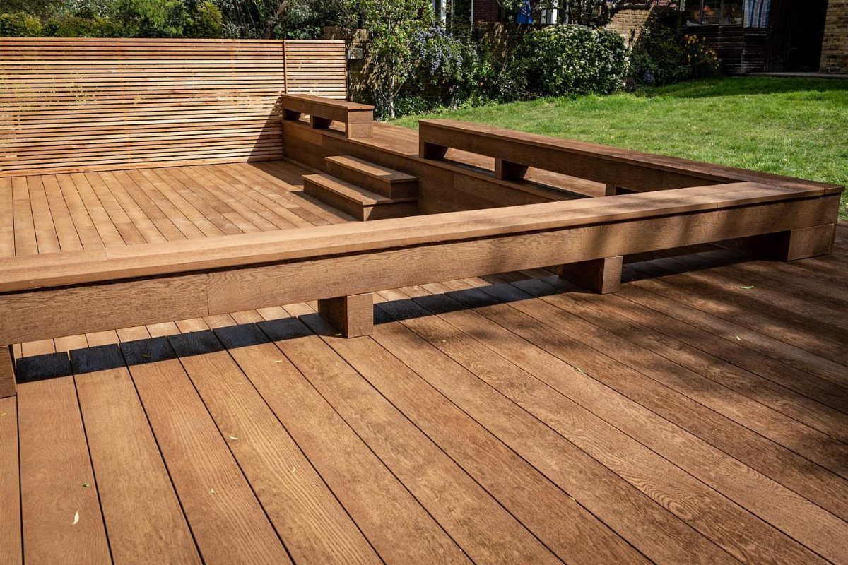 Built-in wooden bench seating integrated into a large brown timber outdoor deck.